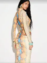 Vestido largo de silueta ajustada con estampado de piel de serpiente en tonos cálidos. Presenta escote profundo con cuello tipo camisa, mangas largas y recortes laterales cut-out que estilizan la figura.