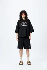 Buzo negro de corte holgado con estampado frontal que dice "Chelsea Heights 97 New York".