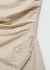 Vestido corto tipo palabra de honor, con diseño recto y drapeado. Presenta una textura con patrón de rayas en relieve y cierre de cremallera invisible en el lateral.