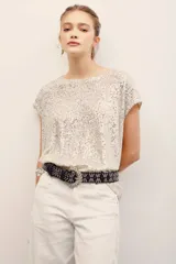 Remera plateada con lentejuelas, de manga corta y cuello redondo.