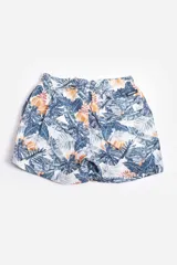 Short de baño celeste con estampado de hojas pequeñas en tonos verdes y blancos. Cuenta con cintura elástica con cordón ajustable, bolsillos laterales y un parche circular con logo en la parte inferior.