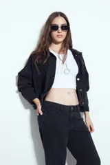 Pantalón de jean negro de tiro medio y corte recto, con diseño de cinco bolsillos y cierre frontal con botón y cremallera.