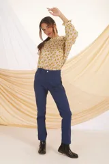 Blusa de manga larga con estampado floral en tonos mostaza y lila, con cuello y puños con volados.