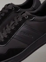 Zapatillas urbanas Calvin Klein de color negro, con detalles en cuero y gamuza. Presentan el logo de la marca en el lateral y suela de goma.