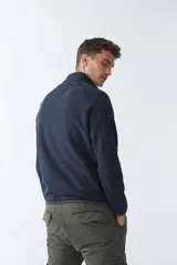 Buzo polar de algodón azul marino con cuello elevado, logo estampado, bolsillo frontal con cierre y medio cierre frontal.