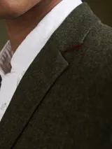 Blazer de corte clásico en color verde oliva con textura jaspeada. Presenta solapas de muesca y cierre frontal con botones.