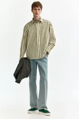 Camisa de popelina de algodón con diseño a rayas en color verde militar y blanco, cuello inglés, cierre frontal de botones, bolsillo en el pecho y mangas largas con puños abotonados.