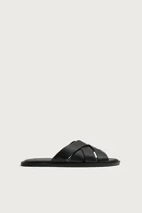 Sandalia plana de hombre confeccionada en piel color negro, con diseño de tiras cruzadas y entrelazadas en el empeine.