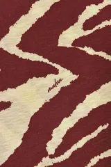 Remera de algodón flameado con estampado de cebra en color rojo y crema, de corte recto y mangas cortas.