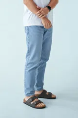 Pantalón de denim regular slim color celeste con efecto lavado localizado.