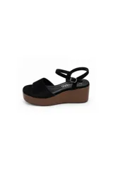 Sandalias de plataforma con cuña efecto madera y capellada de gamuza negra, con tira ancha en la parte delantera y tira ajustable alrededor del tobillo.