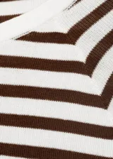 Jersey de punto fino con rayas horizontales marrones y blancas, cuello redondo y manga larga.