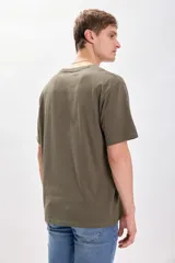 Remera manga corta oversize color verde militar con estampa de texto en gris en el pecho.