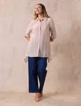 Camisa larga de rayón, con cuello clásico, cierre frontal con botones y mangas regulables con presilla. Presenta un diseño holgado con tajos laterales en el ruedo.