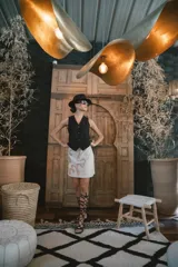 Falda corta negra con aplique de tejido de punto color beige en forma de líneas curvas y orgánicas.