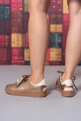 Championes de cuero color cobre con doble cordón, suela marrón y detalles en blanco.