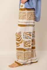 Pantalón holgado de lino blanco con estampado en tonos ocre y azul, de corte recto y cintura elástica fruncida.