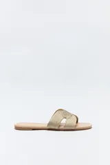 Sandalia baja dorada con capellada trenzada tipo cordón y suela con bordado a tono.