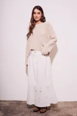 Falda larga blanca de viscosa y lino, con cintura elastizada y cordón ajustable. Presenta bordado calado con motivos florales en el ruedo.