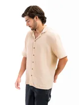 Camisa color crema de tela tetra de algodón, de corte suelto, manga corta y cuello cubano.