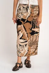 Falda larga con estampado de hojas en tonos beige, marrón y negro, con cintura elastizada y cordón ajustable.