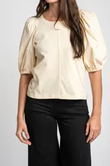 Remera de algodón negro con mangas cortas abullonadas, cuello redondo y costura central frontal.