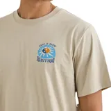 Remera Rhythm de manga corta en color beige, con cuello redondo y diseño liso. Presenta un pequeño estampado gráfico circular en el pecho con texto alusivo a la marca.