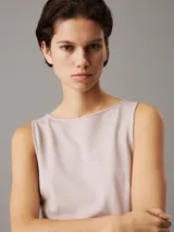 Vestido largo de punto milano color beige, sin mangas, con cuello barco, corte slim y panel trasero recortado.