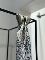 Pañuelo cuadrado tipo bandana de tela tipo seda color manteca con estampado de cachemir en azul marino.