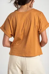Remera color camel, de corte al cuerpo, manga corta con vuelta y cuello redondo.