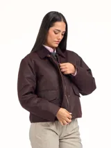 Campera de algodón encerado color bordó, con cuello de pana al tono, cierre frontal con botones a presión metálicos y bolsillos frontales con solapa.