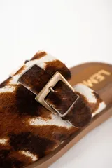 Zuecos con capellada de cuero con estampado animal print, base color marrón y hebilla ajustable.