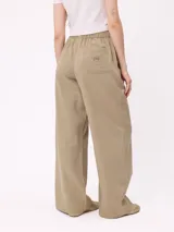 Pantalon de gabardina de corte recto y pata ancha, con cintura elástica y etiqueta decorativa en el frente.