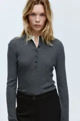 Pantalón sastrero de tiro alto con cierre de botón, piernas acampanadas y pliegues frontales y traseros.