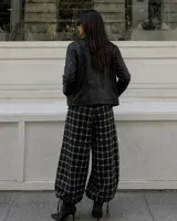Pantalón de corte amplio y holgado con diseño a cuadros, cintura elástica con cordón ajustable y bajos regulables en las piernas.