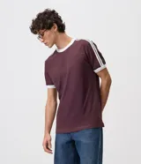 Remera celeste de corte regular, con cuello redondo, mangas cortas y detalles de rayas blancas en los hombros. Cuenta con terminaciones en tono contrastante en cuello y puños.