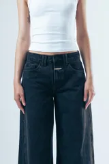 Pantalón de jean estilo wide leg, de tiro alto y corte holgado desde la cadera hasta el ruedo, con diseño de cinco bolsillos y cierre frontal.