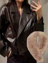 Campera de cuero marrón con cuello amplio de piel sintética en tono beige. Presenta un diseño estilo bomber con puños y ruedo elásticos, mangas largas y cierre frontal.