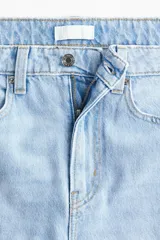 Jean wide leg de tiro alto en denim de algodón celeste claro, con diseño de cinco bolsillos, cierre de cremallera y botón metálico.