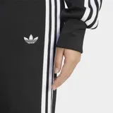 Pantalón acampanado Adidas de la colección Adicolor, color negro con las icónicas tres tiras blancas a los lados y el logo del trifolio bordado.