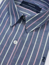 Camisa de manga larga de corte suelto, con diseño de rayas verticales en tonos azul, blanco y rosado, cuello camisero tradicional y cierre frontal con botones.