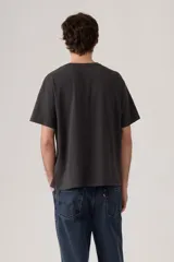 Remera negra de corte vintage con estampado de botas vaqueras y sombrero en el pecho.