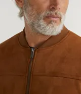 Chaqueta bomber azul marino lisa, con cierre frontal, cuello redondo y bolsillos laterales.