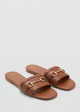 Sandalias bajas color marrón con tira ancha sobre el empeine y detalle de hebilla dorada.