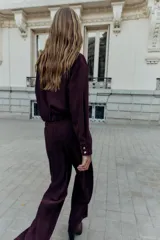 Cazadora bomber de Zara, de color bordó, con cuello de solapa, manga larga, bolsillos de vivo en el delantero y bajo elástico. Cuenta con cierre frontal de cremallera metálica.