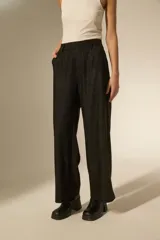 Pantalon de vestir negro con acabado brillante tipo glitter, de corte ancho y tiro alto.