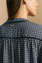 Camisa de manga larga con silueta relajada, estampado a rayas verticales en blanco y gris, escote abierto con botones frontales y puños elastizados.