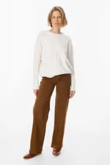 Sweater de punto negro con diseño de trenzas verticales en el frente y cuello redondo. Presenta un corte holgado con puños y ruedo acanalados.