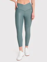 Calza deportiva de tiro alto con acabado brillante y cintura cruzada en forma de V. Confeccionada en tejido elástico que se ajusta al cuerpo, cuenta con detalle de silicona en el interior de la cintura para mayor sujeción.