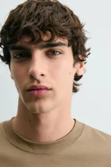 Camiseta de corte relajado con cuello redondo y manga corta, confeccionada en tejido de algodón liso.